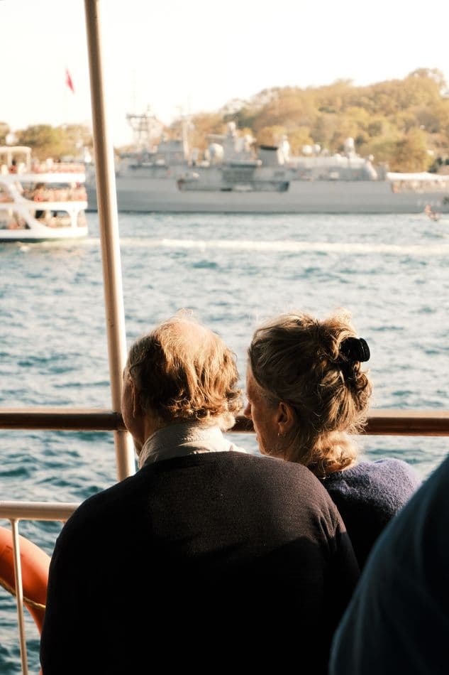 An older couple seated together on a boat, looking out over the water in Istanbul.